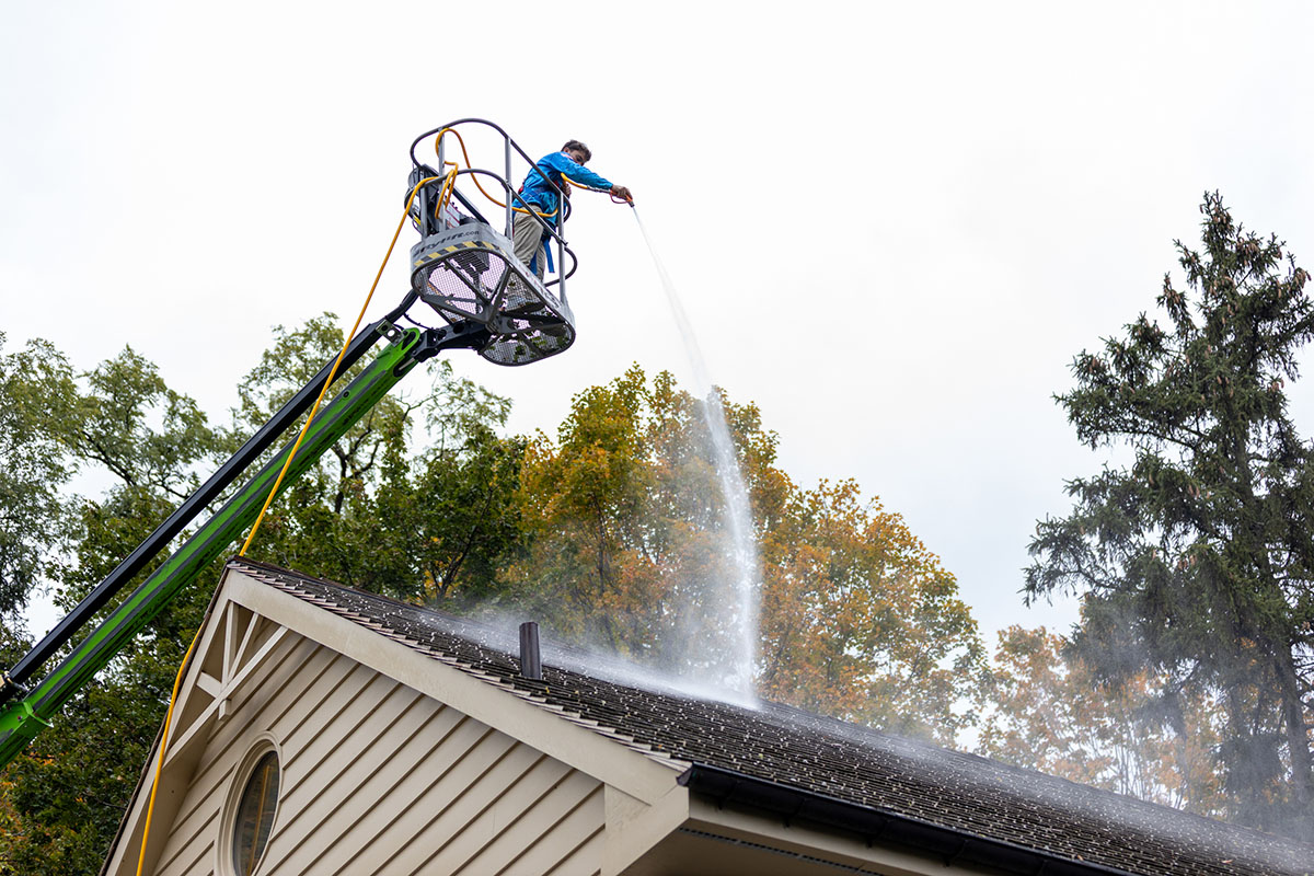 Landon Yorgey on a lift spraying a roof in Berks County