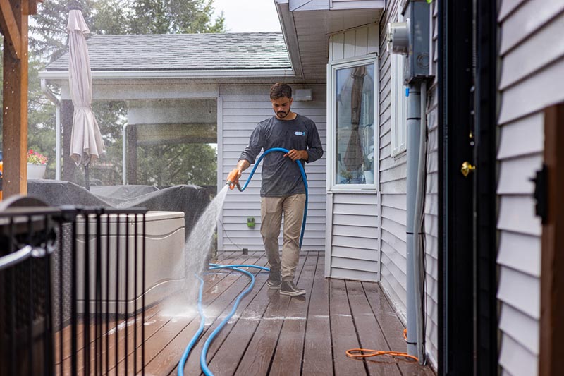 Owner Landon Yorgey rinsing a home deck
